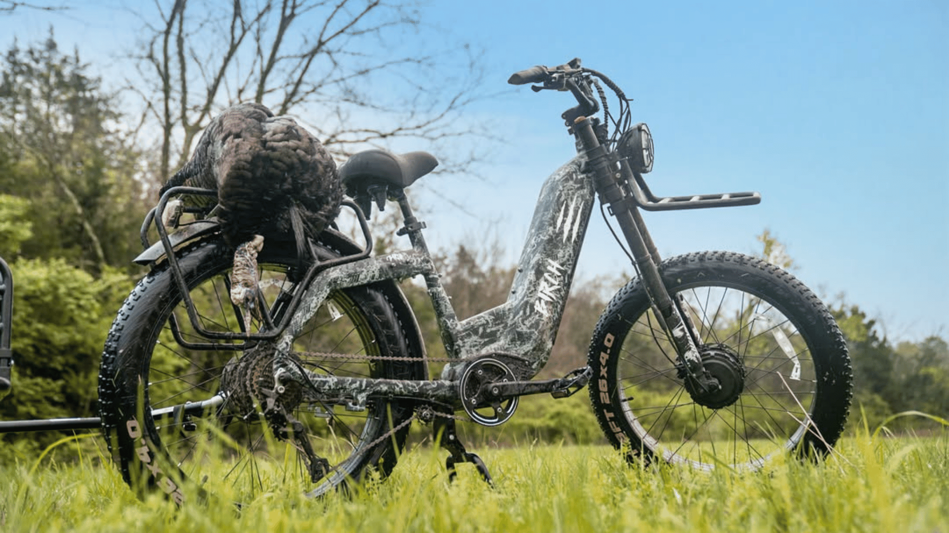 camo ebike with turkey on the back in a grass field